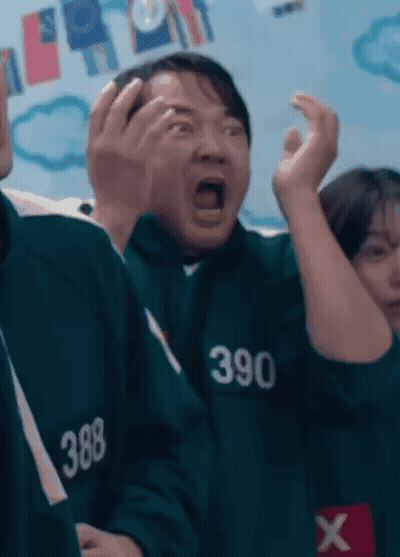 Man In Suit In Front Of Squid Game 3 Sign GIF