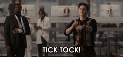 Man In Suit In Front Of Tick Tock Sign GIF