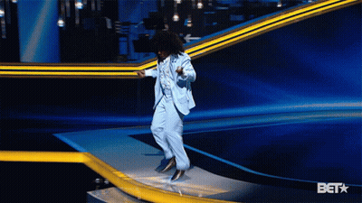 Man In Suit Jumping On Stage With Bet Background GIF