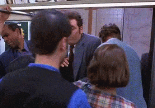 Man In Suit Kissing Another On Subway GIF