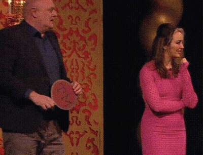 Man In Suit Kneeling Next To Woman In Pink Shirt GIF