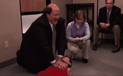 Man In Suit Kneeling Next To Woman In Purple Vest GIF