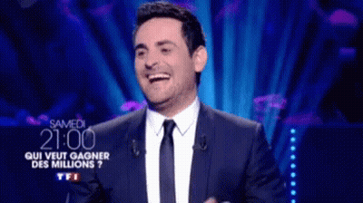 Man In Suit Laughing At Screen GIF