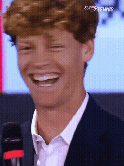 Man In Suit Laughing At Super Tennis Logo GIF