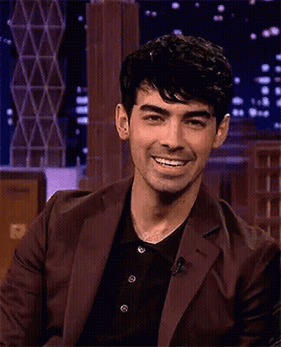 Man In Suit Laughing Eyes Closed On Stage GIF