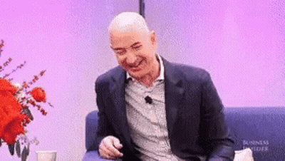 Man in Suit Laughing on Couch