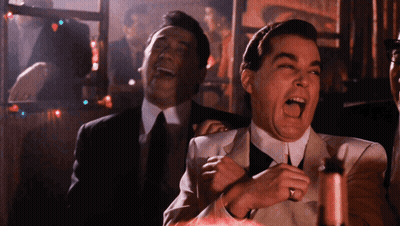 Man In Suit Laughing While Another Man Looks On GIF