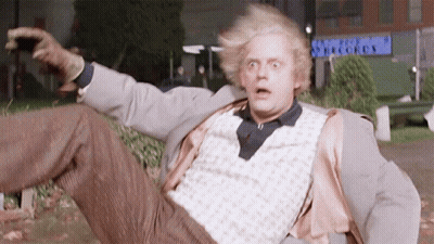 Man In Suit Laying On Ground In Front Of Records Building GIF
