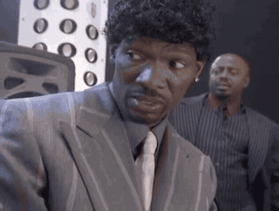Man In Suit Looking At Camera With Another Man Behind GIF