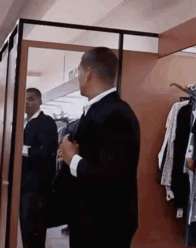 Man In Suit Looking At Himself In Mirror GIF