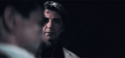 Man In Suit Looking At Man In Dark Room GIF