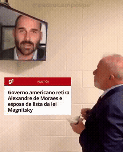 Man in Suit Looking at TV Saying Governo Americano Retira