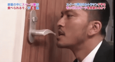 Man In Suit Looking Through Door Handle With Chinese Writing GIF