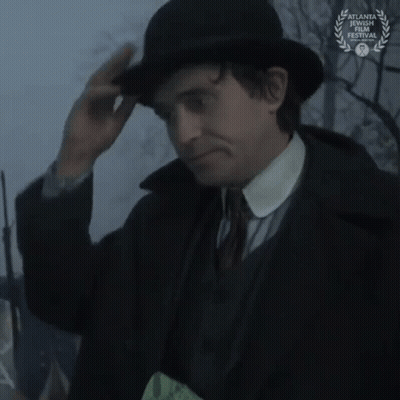 Man In Suit Looking Through Magnifying Glass With Laurel Wreath GIF