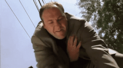 Man In Suit Lying On Ground Holding Chest GIF