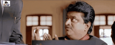 Man In Suit Making Funny Face At Cinema Sign GIF