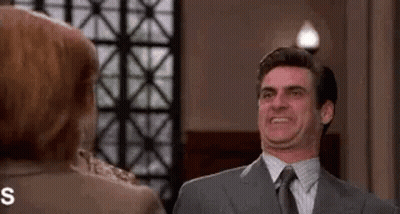 Man In Suit Making Funny Face At Woman GIF