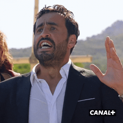 Man In Suit Making Funny Face By Canal+ Sign GIF
