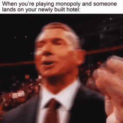 Man In Suit Making Funny Face Playing Monopoly GIF
