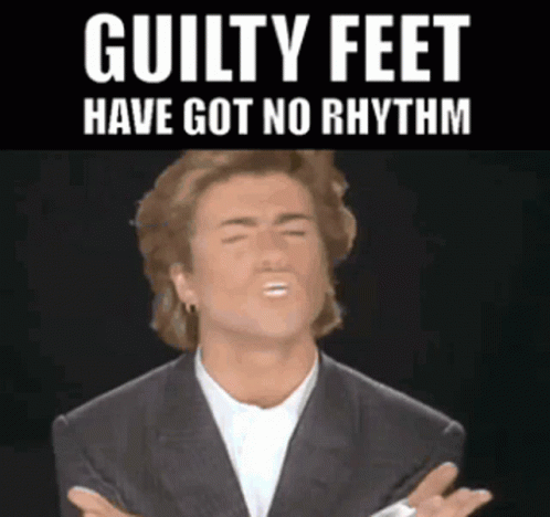 Man In Suit Making Funny Face With Guilty Feet Have Got No Rhythm GIF