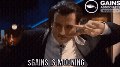 Man In Suit Making Peace Sign Saying S Gains Is Mooning GIF