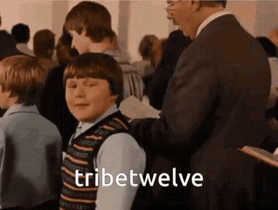 Man In Suit Next To Boy In Striped Vest GIF