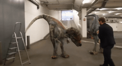 Man In Suit Next To Dinosaur GIF