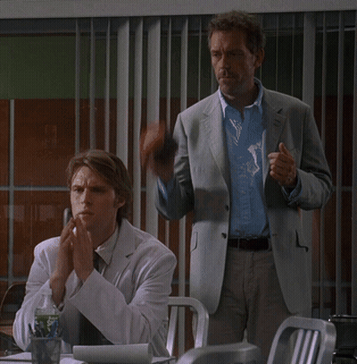 Man In Suit Next To Man In Lab Coat Covering Mouth GIF