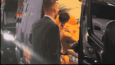 Man In Suit Next To Man In Wheelchair In Front Of Ambulance Van GIF