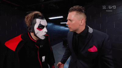 Man In Suit Next To Masked Man GIF