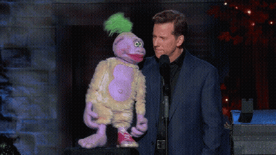 Man In Suit Next To Purple Puppet With Green Mohawk GIF