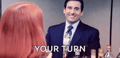 Man In Suit Next To Redhead Woman Holding Wine GIF