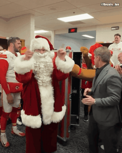 Man In Suit Next To Santa Claus Costume GIF