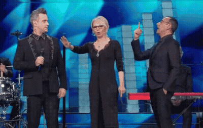 Man In Suit Next To Woman In Black Dress And Man In Suit GIF