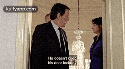 Man In Suit Next To Woman In Blue Suit GIF