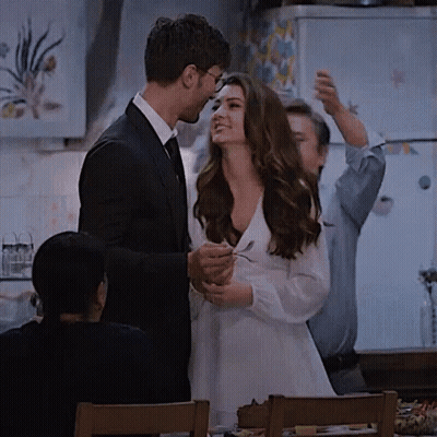 Man In Suit Next To Woman In White Dress Holding Spoon GIF