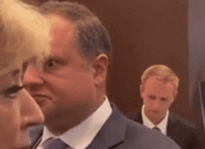 Man In Suit Next To Woman In White Shirt GIF