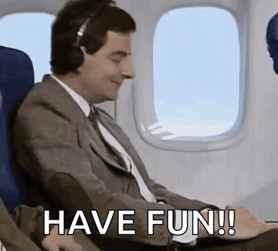 Man In Suit On Airplane Wearing Headphones Saying Have Fun GIF