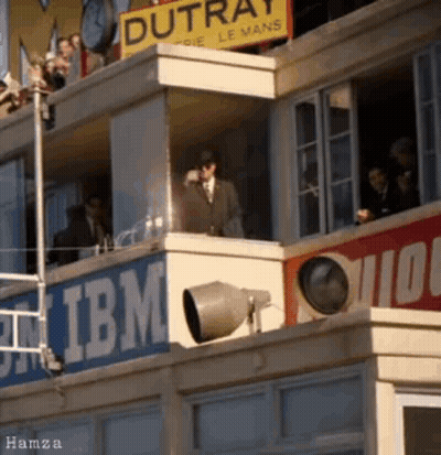 Man In Suit On Balcony Overlooking IBM Building GIF