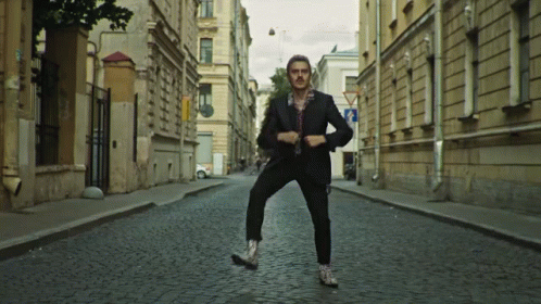 Man In Suit On Cobblestone Street GIF