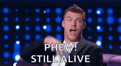Man In Suit On Couch Saying Phew Still Alive GIF