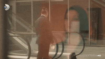 Man In Suit On Escalator In Front Of Kanal.com.tr Building GIF