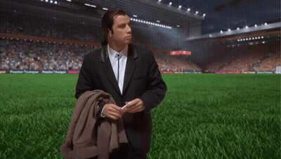 Man In Suit On Soccer Field With Premier League Banner GIF