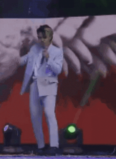 Man In Suit On Stage With Microphone GIF
