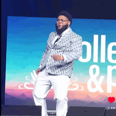 Man In Suit On Stage With Screen Saying Colle & P GIF