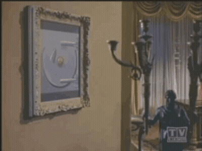 Man In Suit Opening Safe With TV Guide Logo GIF