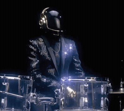 Man In Suit Playing Drums In Dark Room GIF
