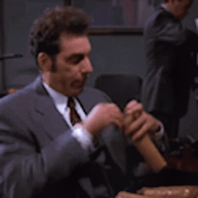 Man In Suit Playing Flute At Table GIF