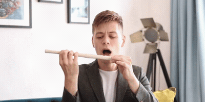 Man In Suit Playing Flute With Open Mouth GIF
