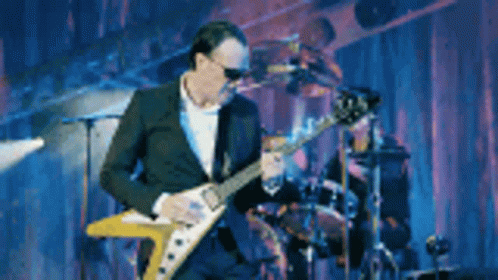 Man In Suit Playing Guitar On Stage GIF
